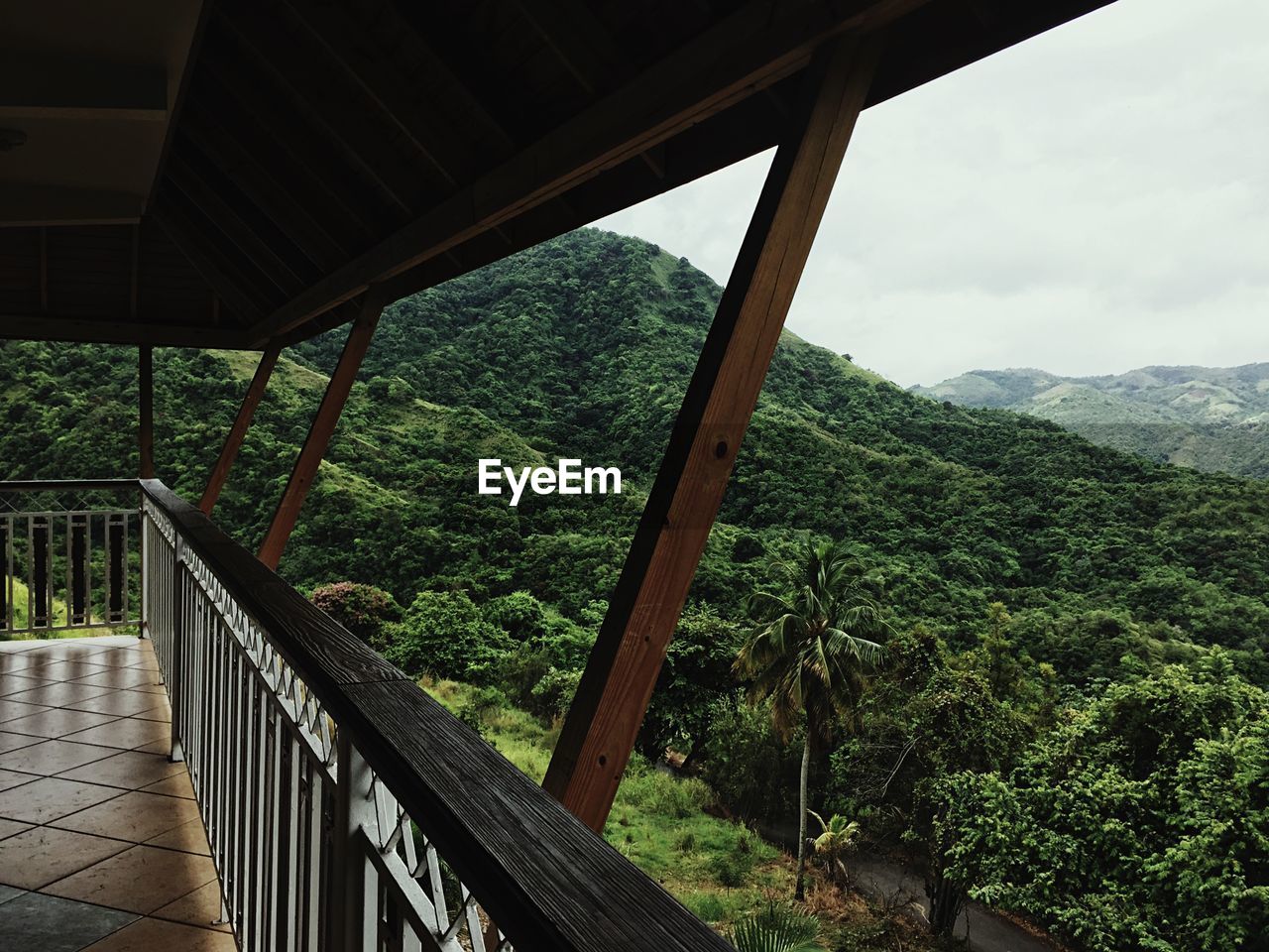 Scenic view of tree mountains against sky seen through balcony