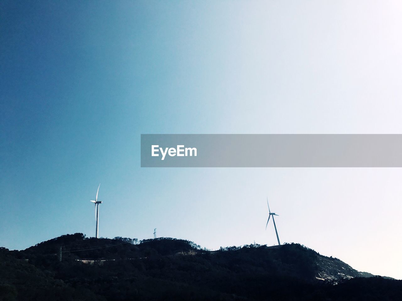 LOW ANGLE VIEW OF WINDMILLS AGAINST SKY