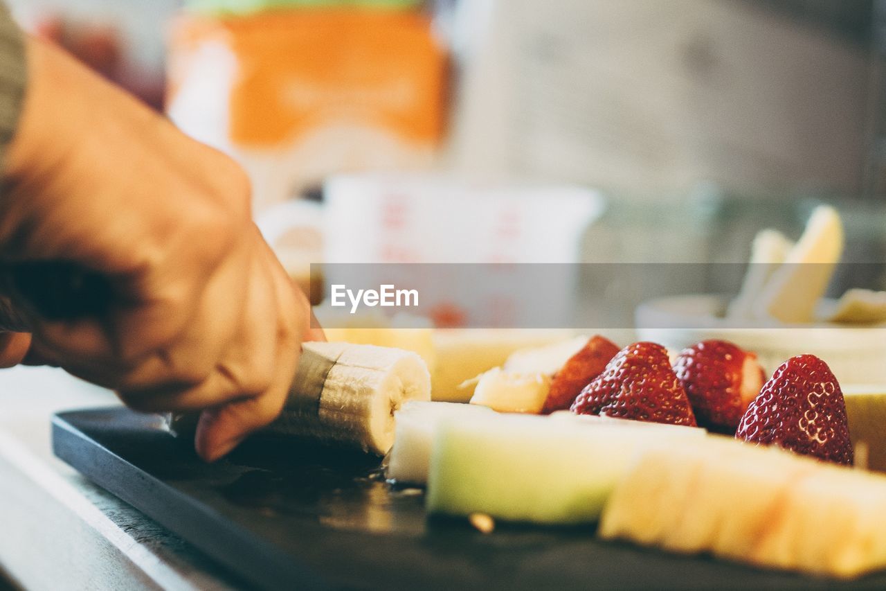 High angle view of person cutting fruits