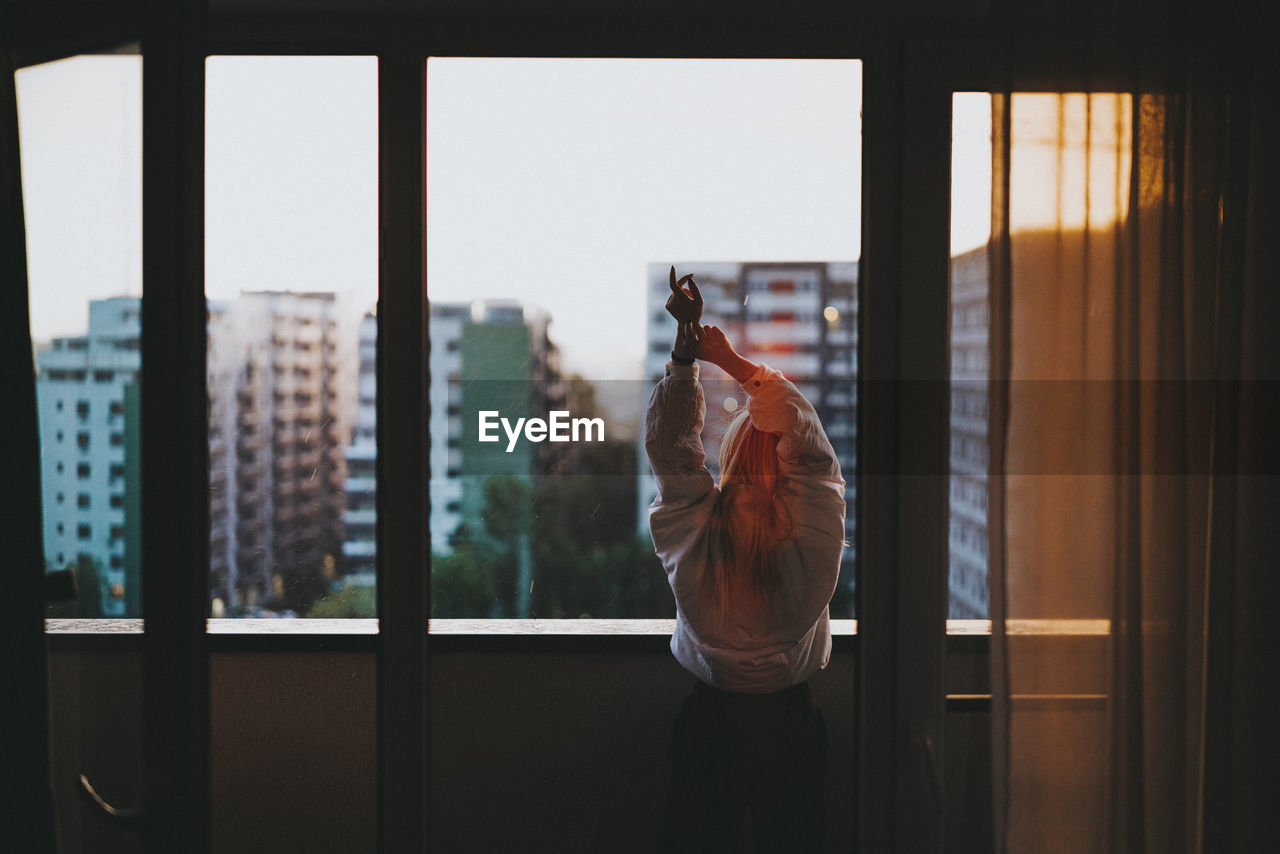 Rear view of woman standing in balcony