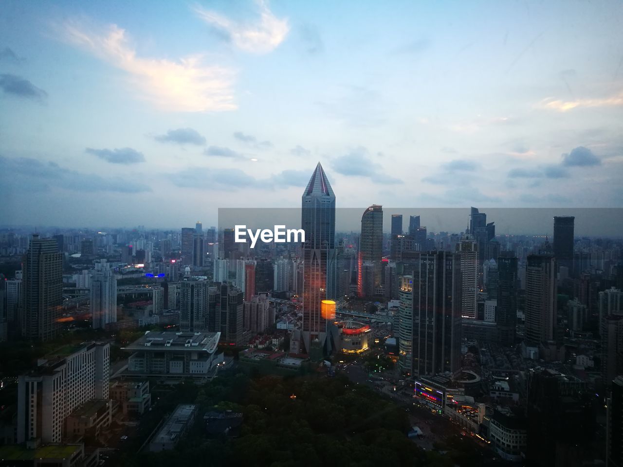 High angle view of illuminated cityscape against cloudy sky