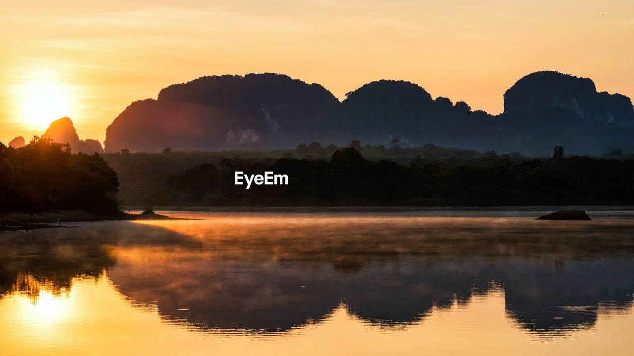 Limestone mountains and motion fog or mist over lake in sunrise, nong thale, krabi, thailand. 