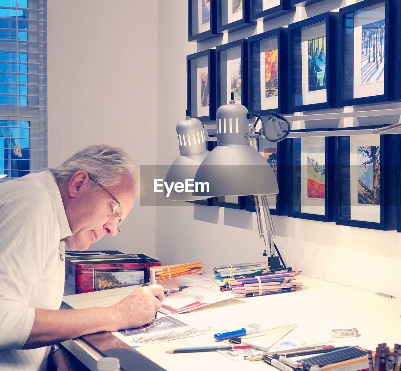 Side view of artist sketching at desk in office