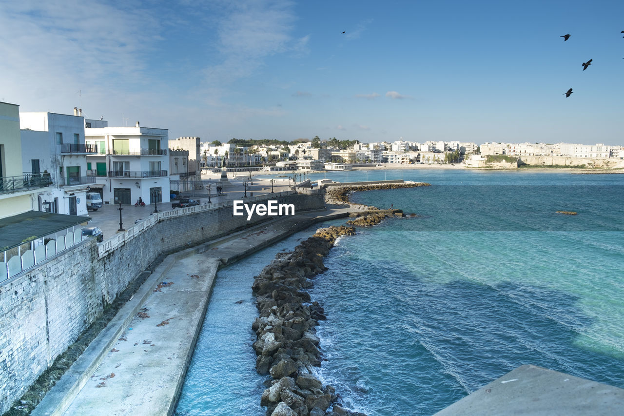 View of city by sea against sky