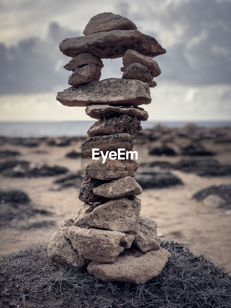 Close-up of stone stacked at beach against sky