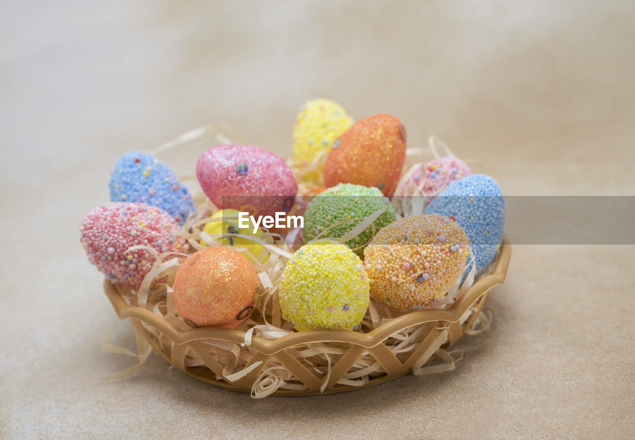 Nest basket with colorful easter eggs and eggshell figurine, creative craft with kids