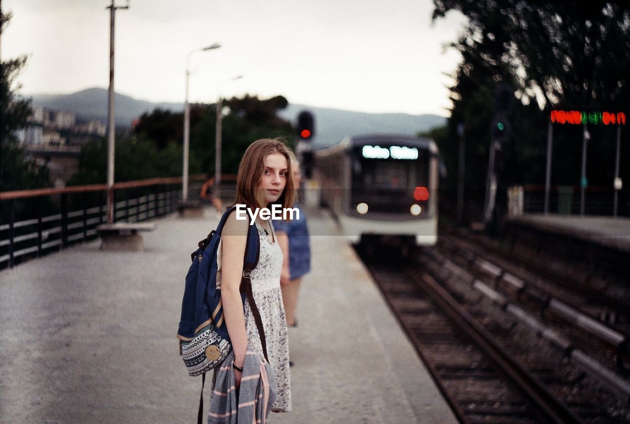 Woman on railroad station platform in city