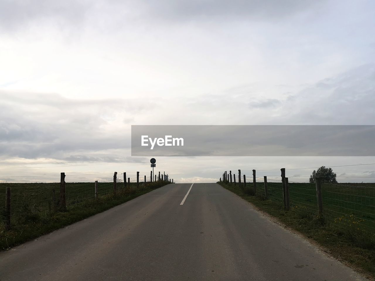 Empty road along landscape against sky