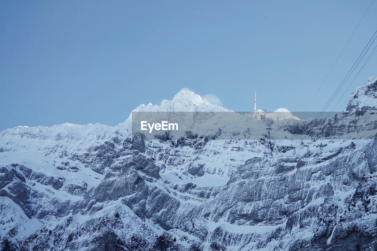 Scenic view of snowcapped mountains against clear blue sky