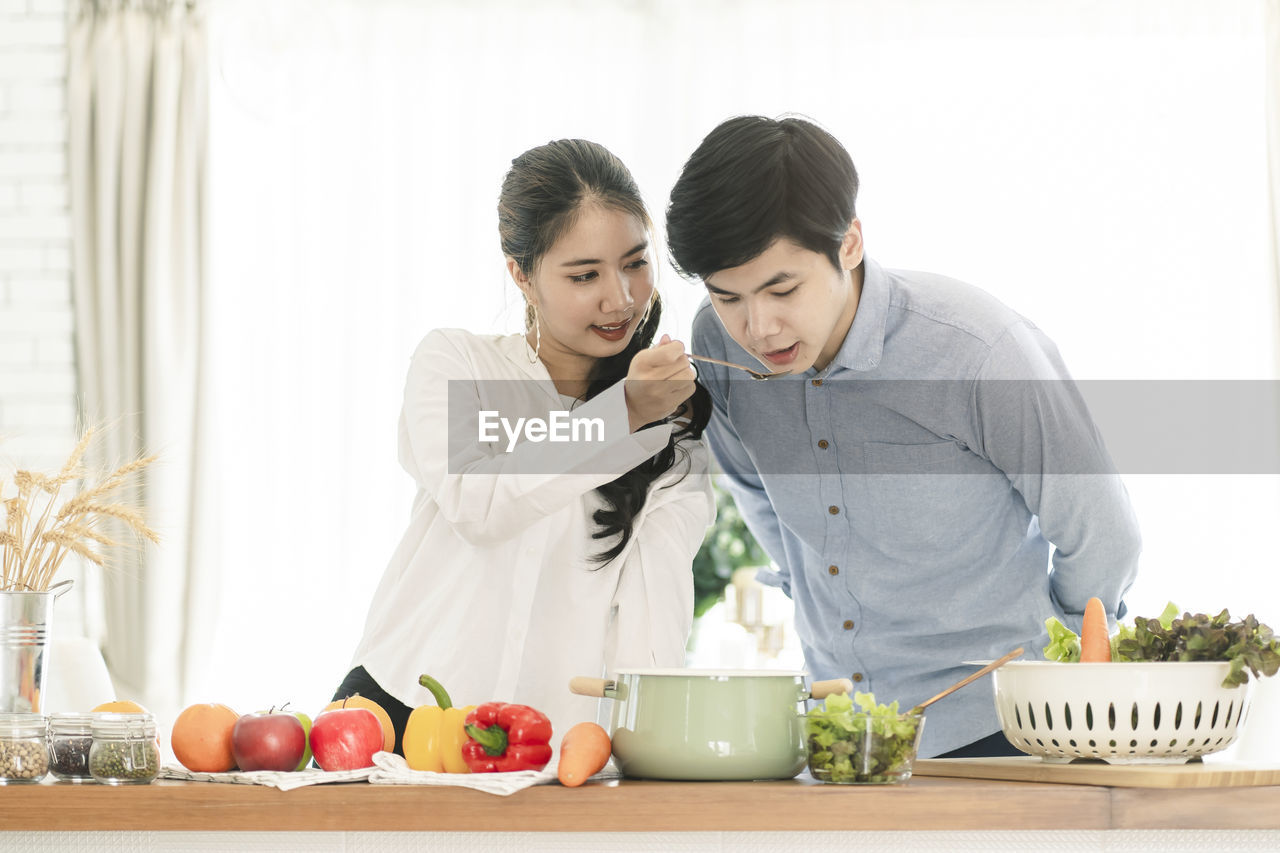 YOUNG COUPLE LOOKING AT FOOD