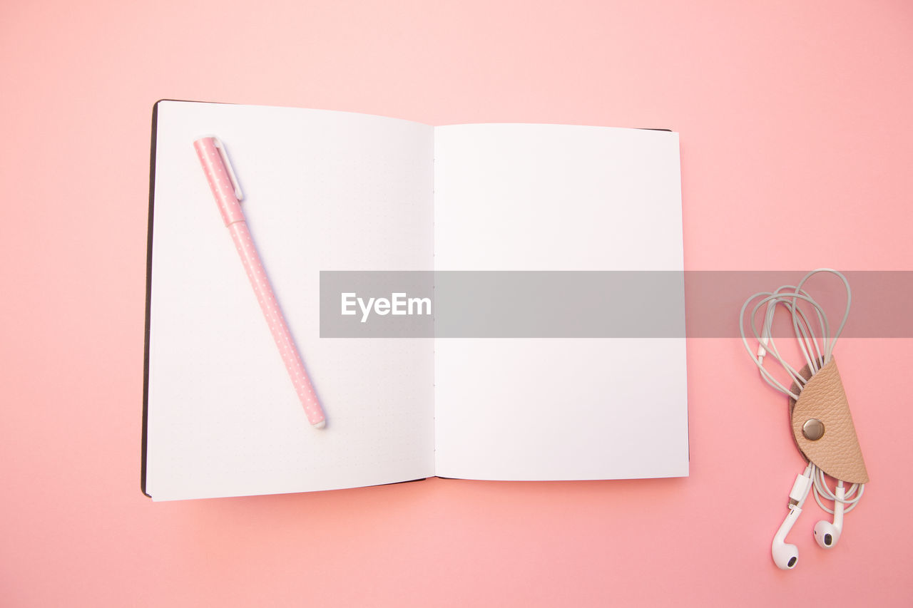 Directly above shot of open book on pink background