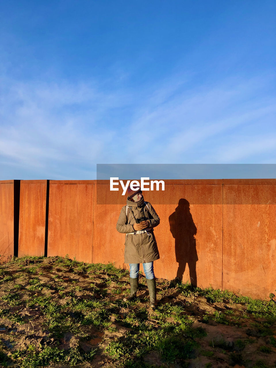 Rear view of women standing against blue sky