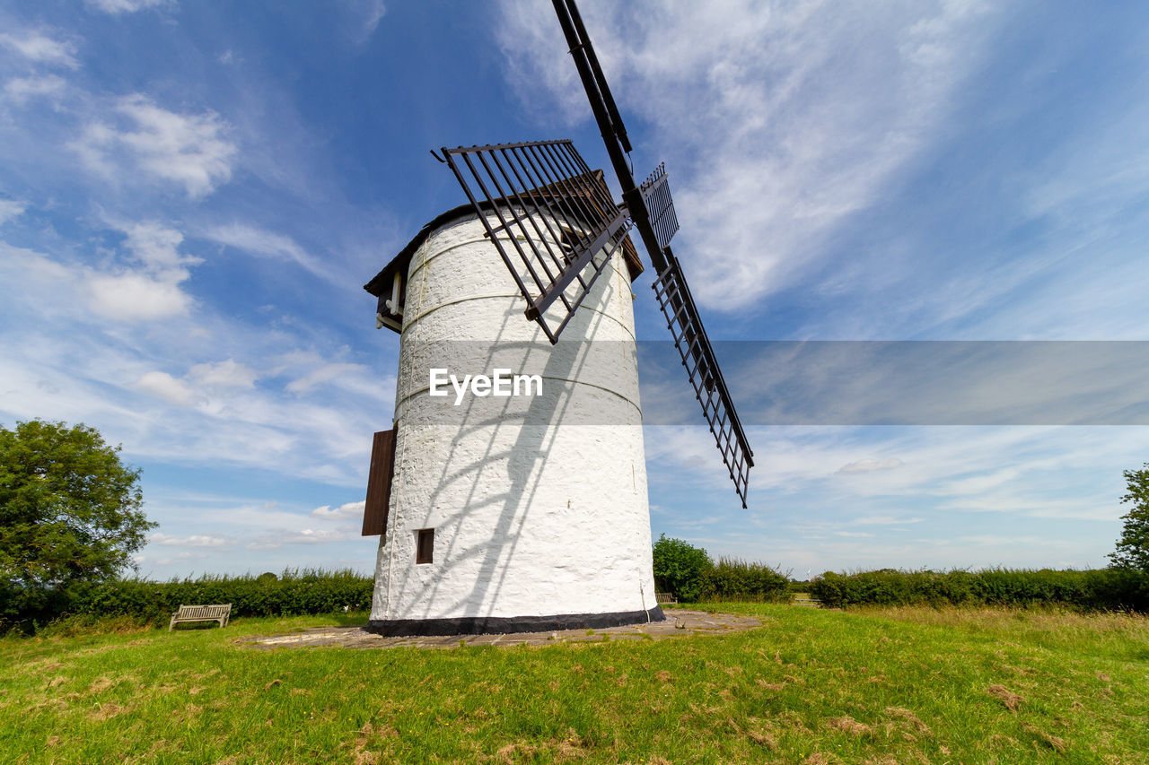 Traditional windmill on field against sky