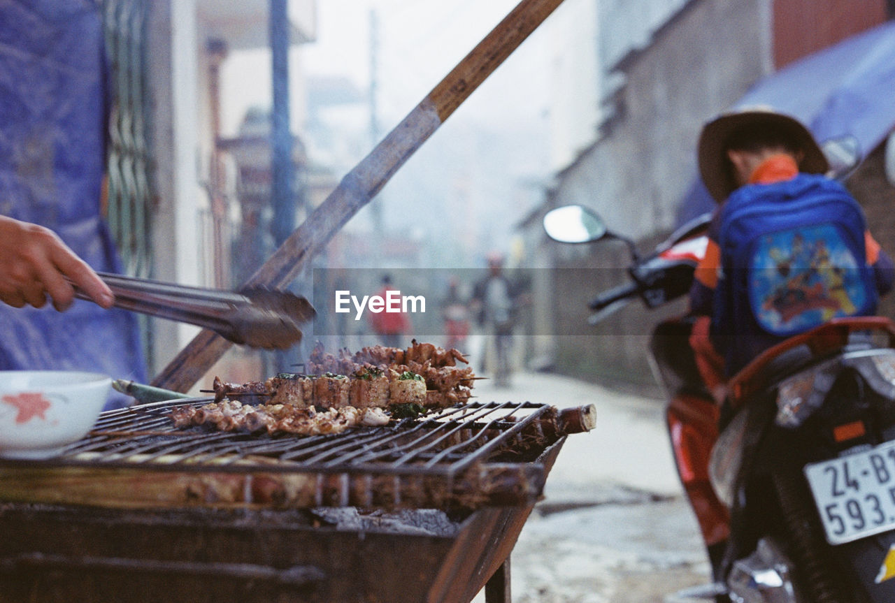 PEOPLE PREPARING FOOD AT MARKET STALL