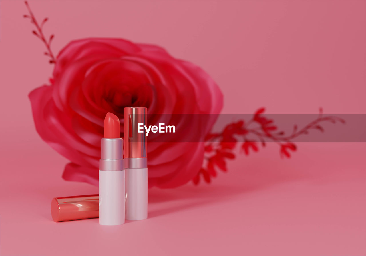 CLOSE-UP OF PINK FLOWER ON TABLE AGAINST COLORED BACKGROUND