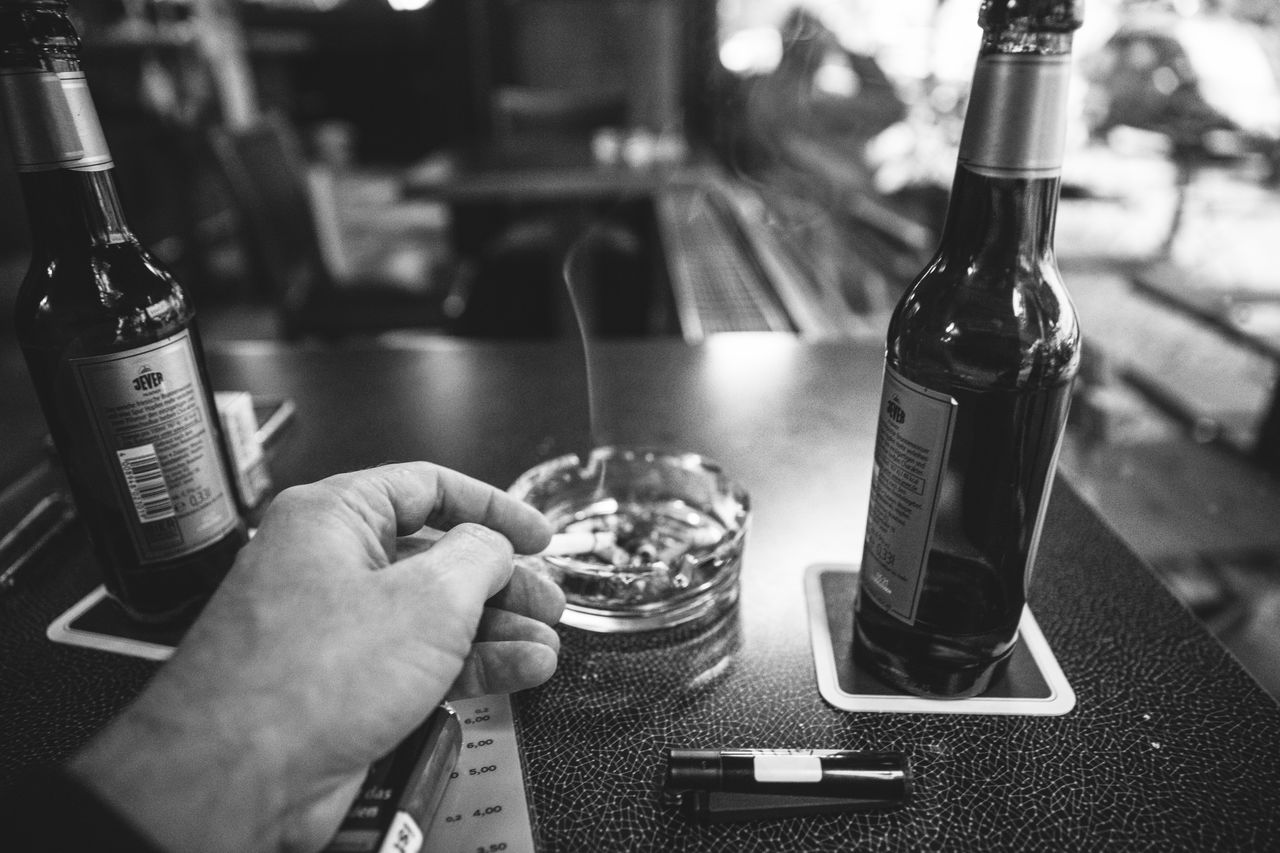 bottle, black, hand, food and drink, drink, refreshment, alcoholic beverage, black and white, one person, container, alcohol, monochrome, monochrome photography, indoors, holding, adult, food, men, focus on foreground, wine bottle, business, lifestyles, wine, glass