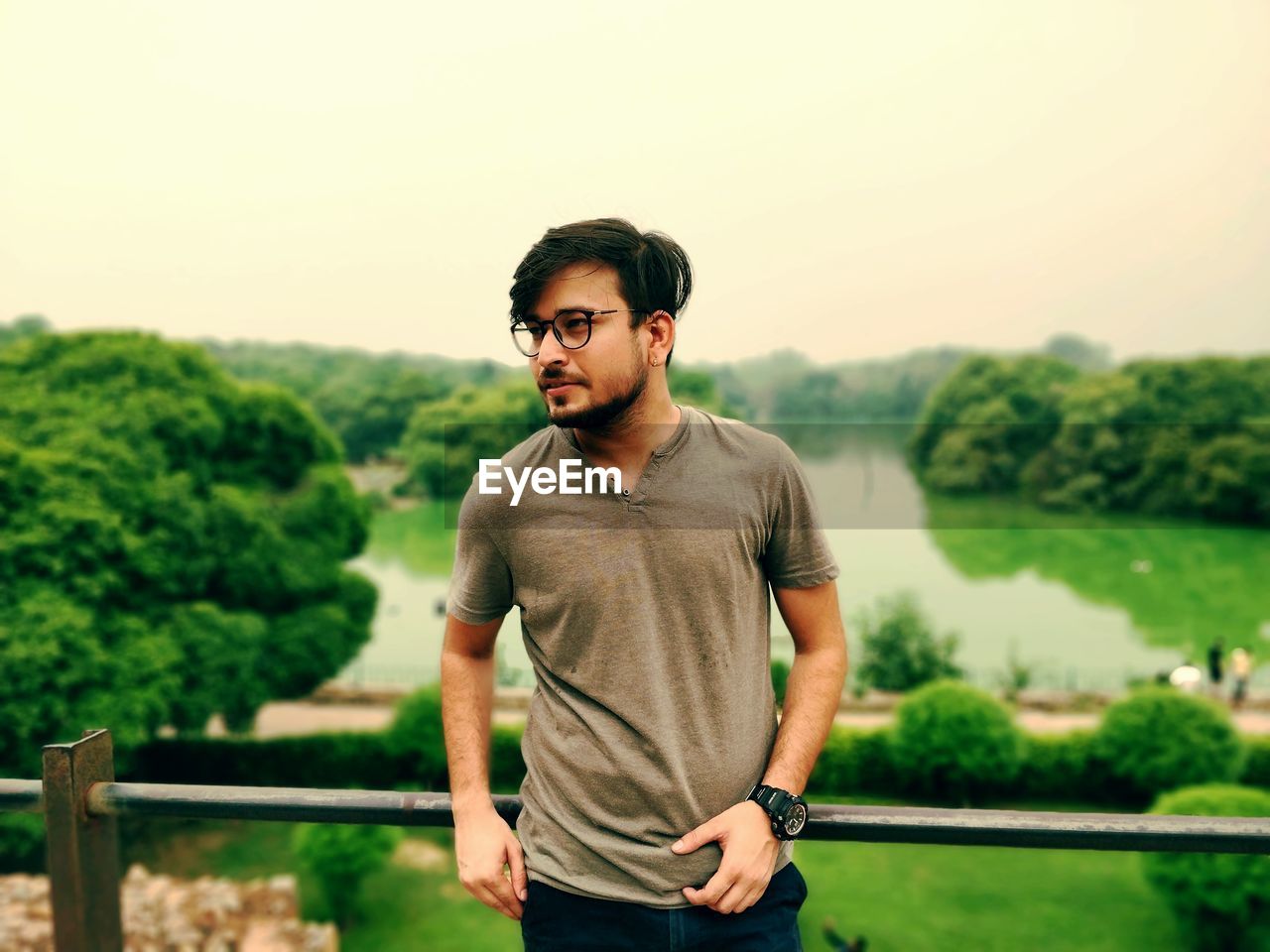 Young man standing against lake