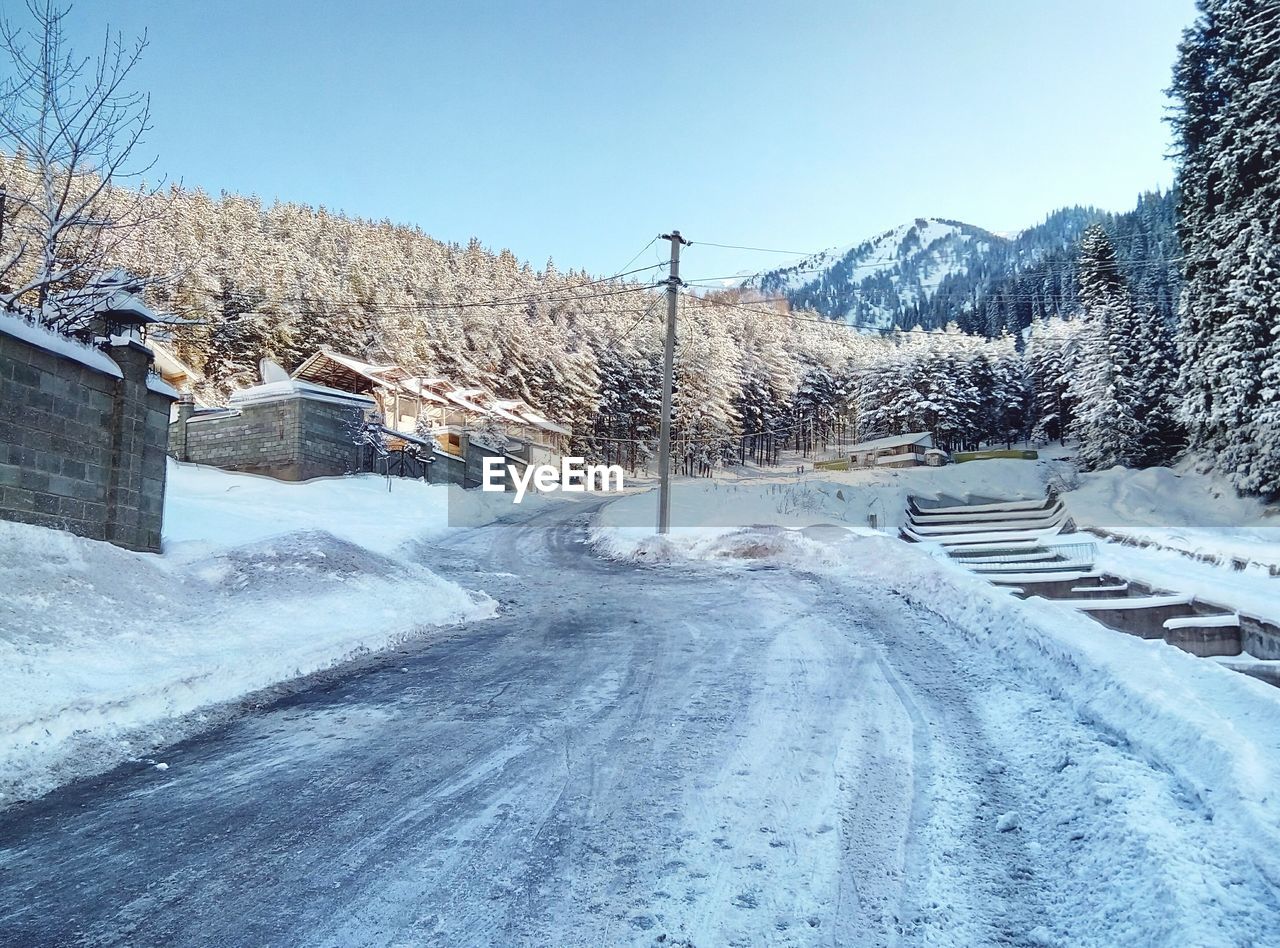 Snow covered road against clear sky