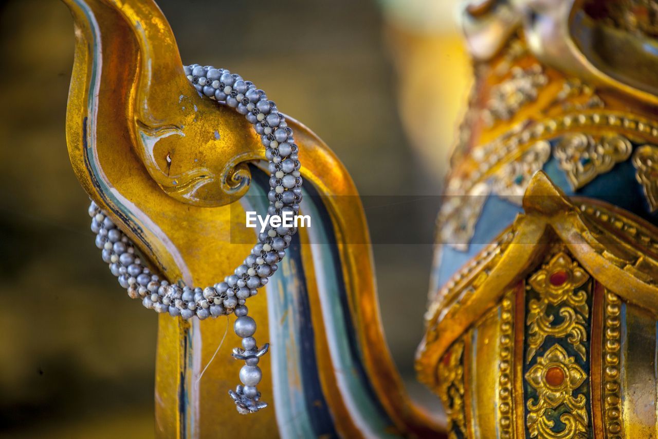 Close-up of a golden statue against blurred background