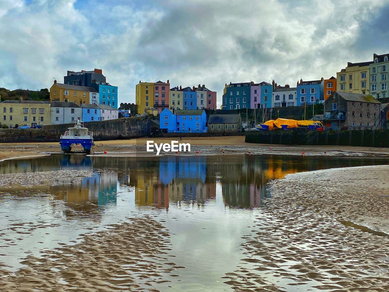 Tenby harbour with houses reflected in the pool of water.