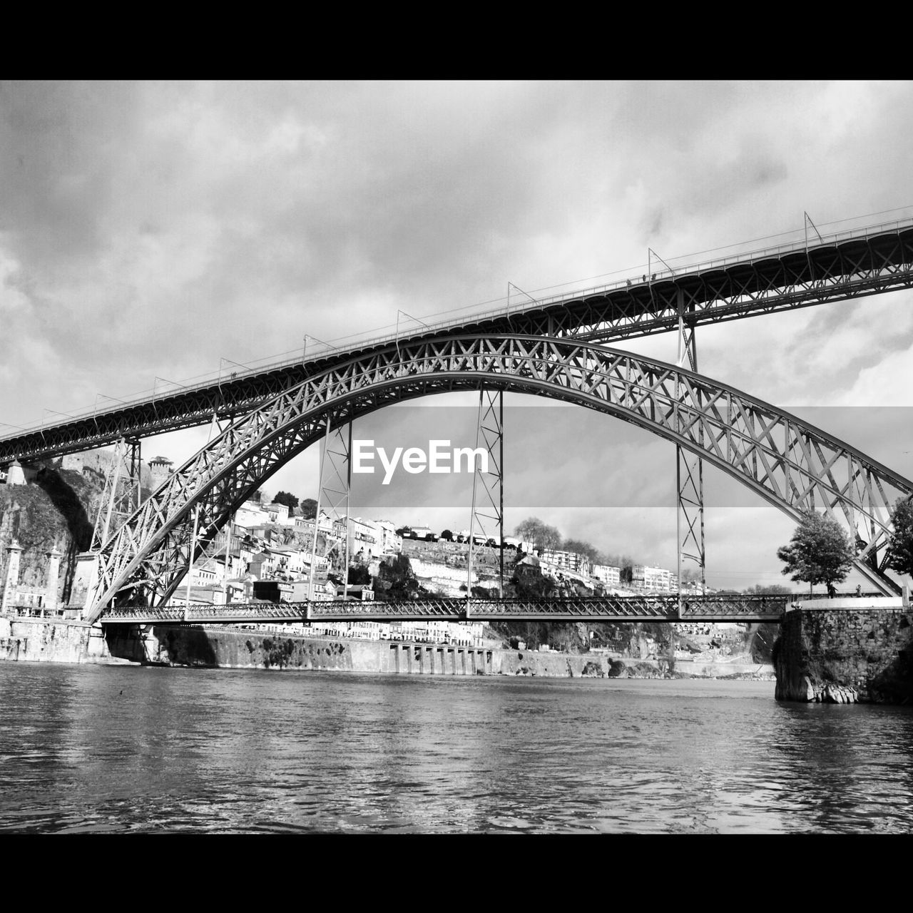 Dom luis i bridge over douro river against cloudy sky