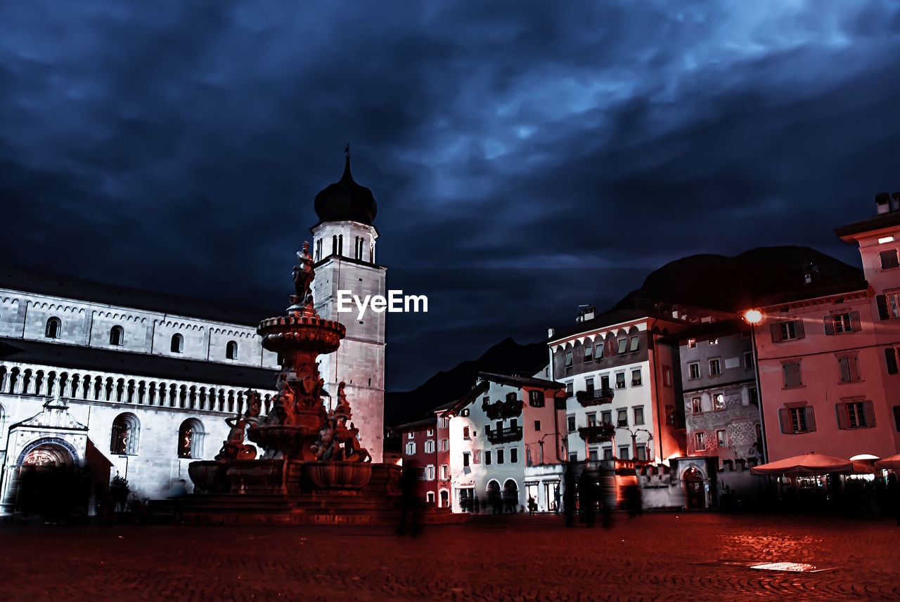 ILLUMINATED CLOCK TOWER AGAINST SKY AT NIGHT IN CITY