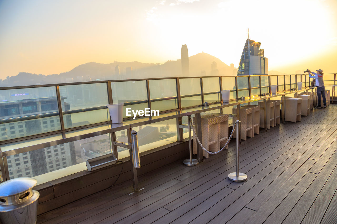 RAILING BY SEA AGAINST SKY AT SUNSET