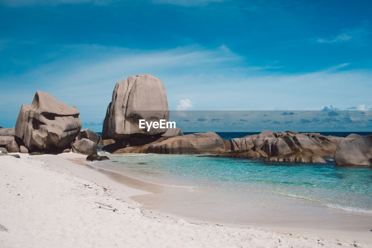 Rock formations on beach against sky