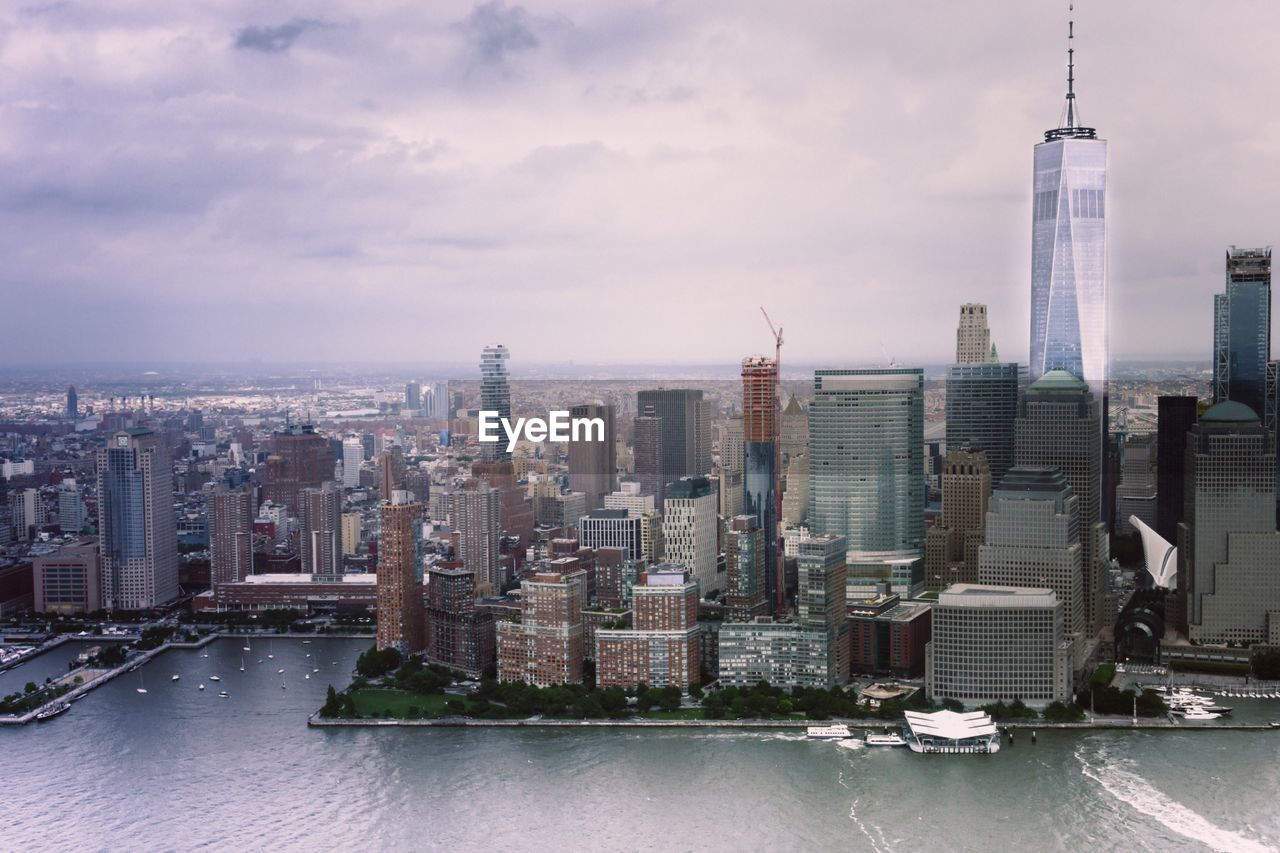 One world trade center by buildings in city against sky