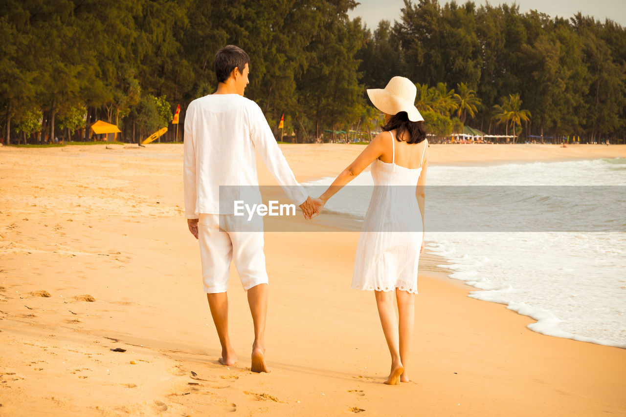 Rear view of couple standing on beach