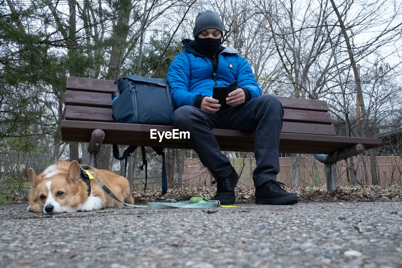 MAN AND DOG SITTING ON BENCH