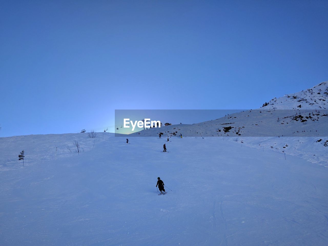 PEOPLE ON SNOW AGAINST CLEAR BLUE SKY