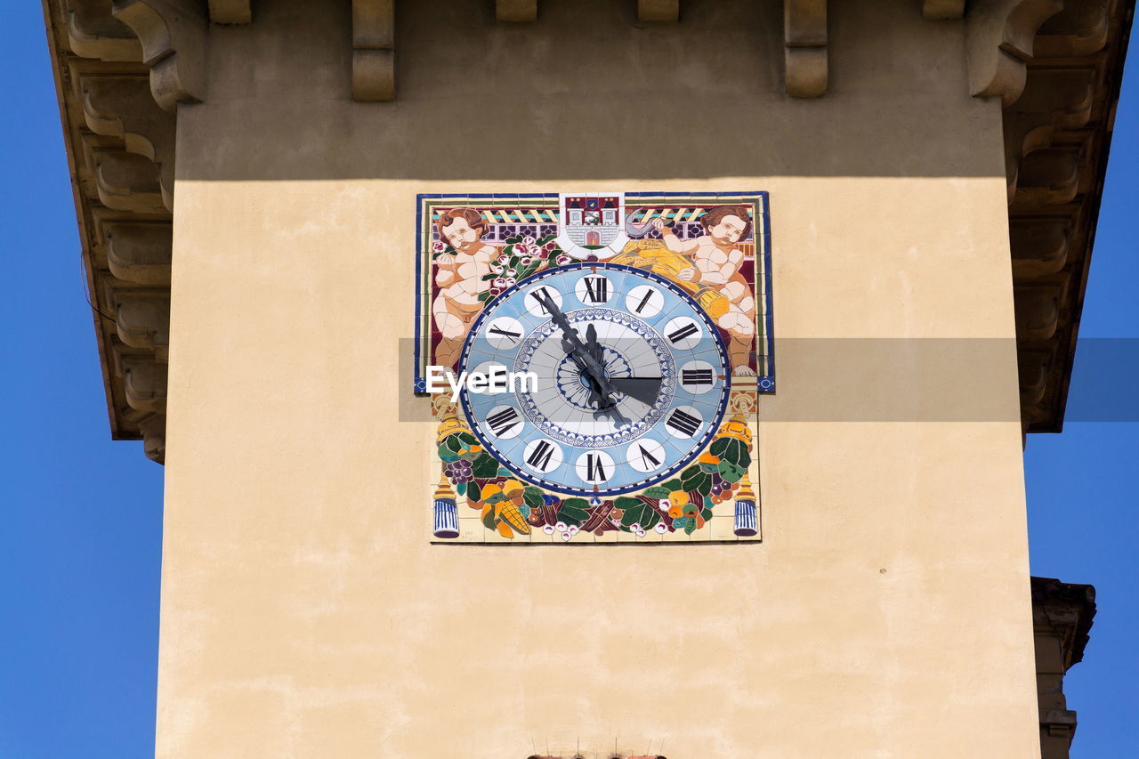 LOW ANGLE VIEW OF CLOCK ON WALL IN BUILDING