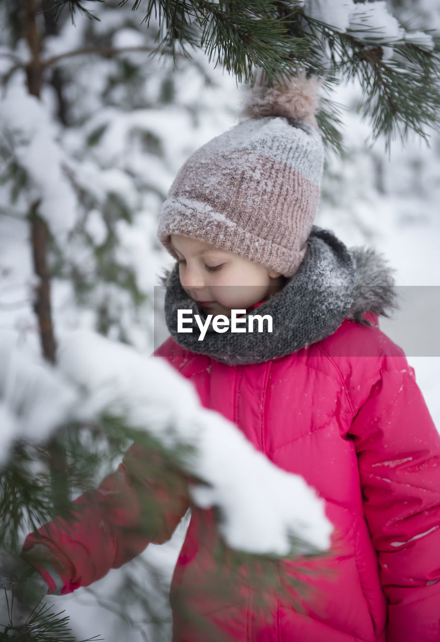 Boy in snow covered tree