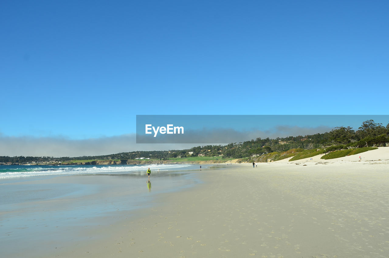 Scenic view of beach against clear blue sky