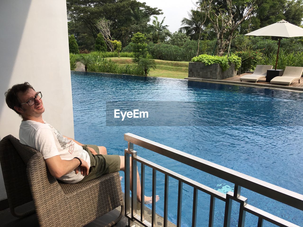 Man sitting by swimming pool