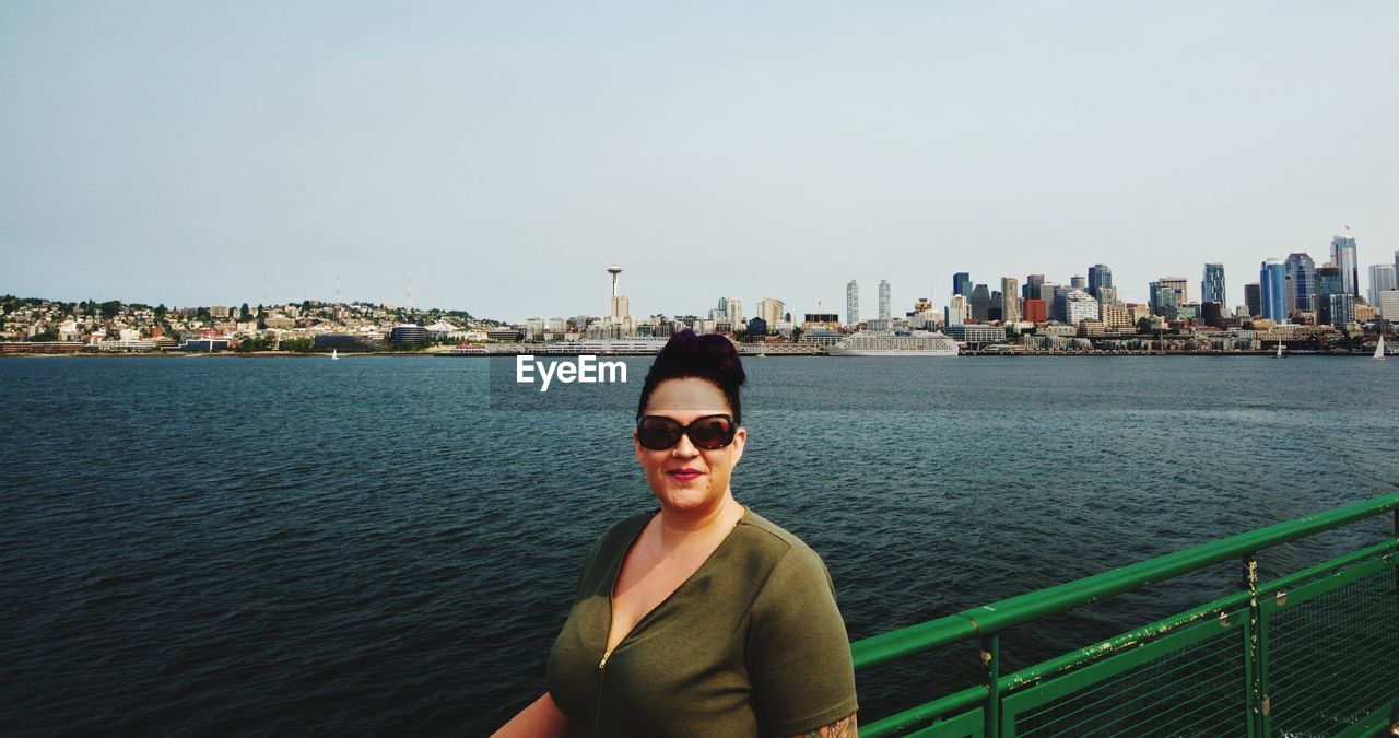 Woman standing by lake in city