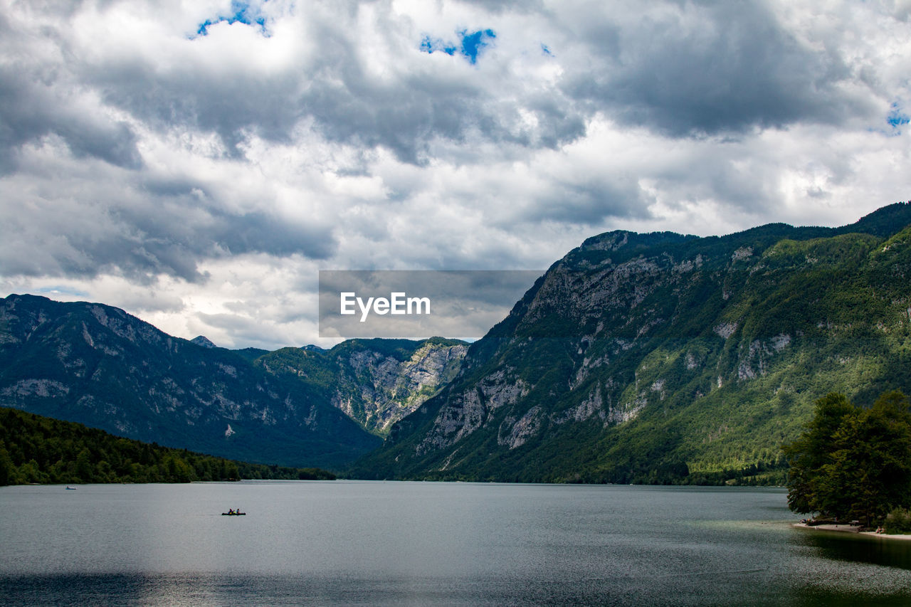 Scenic view of lake by mountains against sky