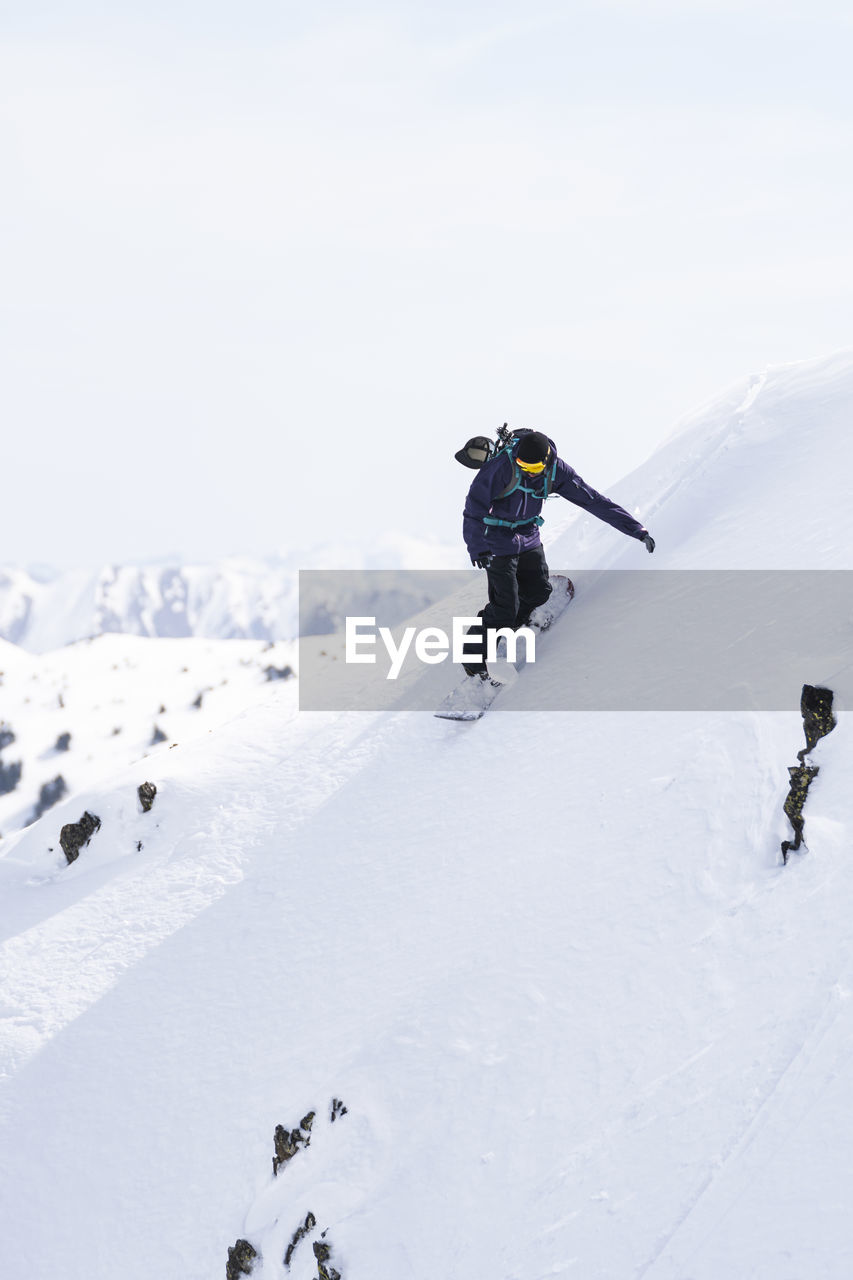 Mature man snowboarding on pyrenees mountain slope, catalonia, spain