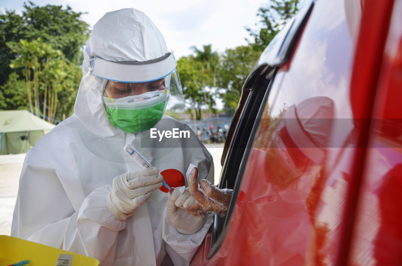 Doctor examining person from car