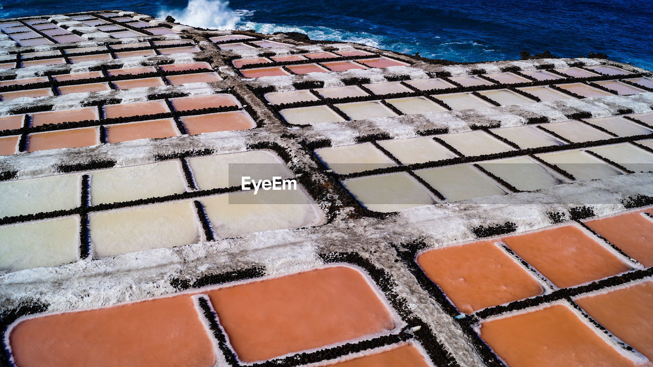 High angle view of salt flat sea salk farm water fields multicolour texture background 