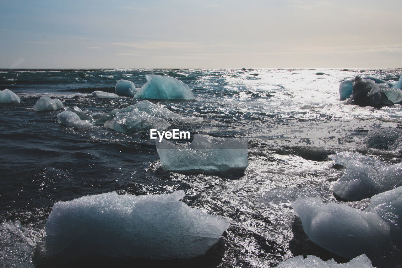 ROCKS ON BEACH AGAINST SKY