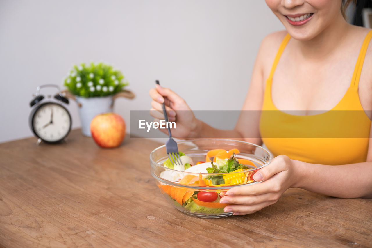 MIDSECTION OF WOMAN MAKING FRUITS