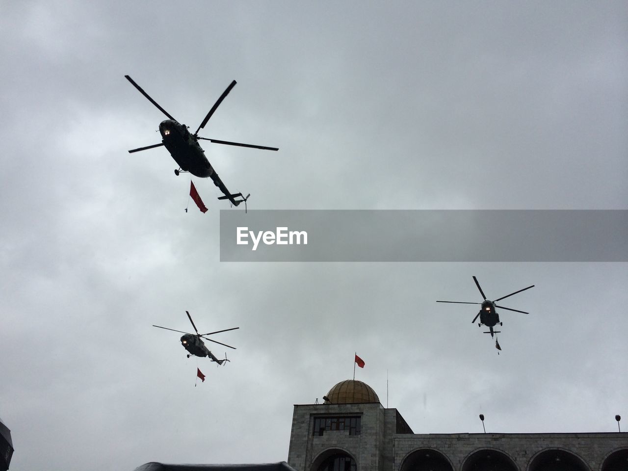 Low angle view of helicopters flying in sky