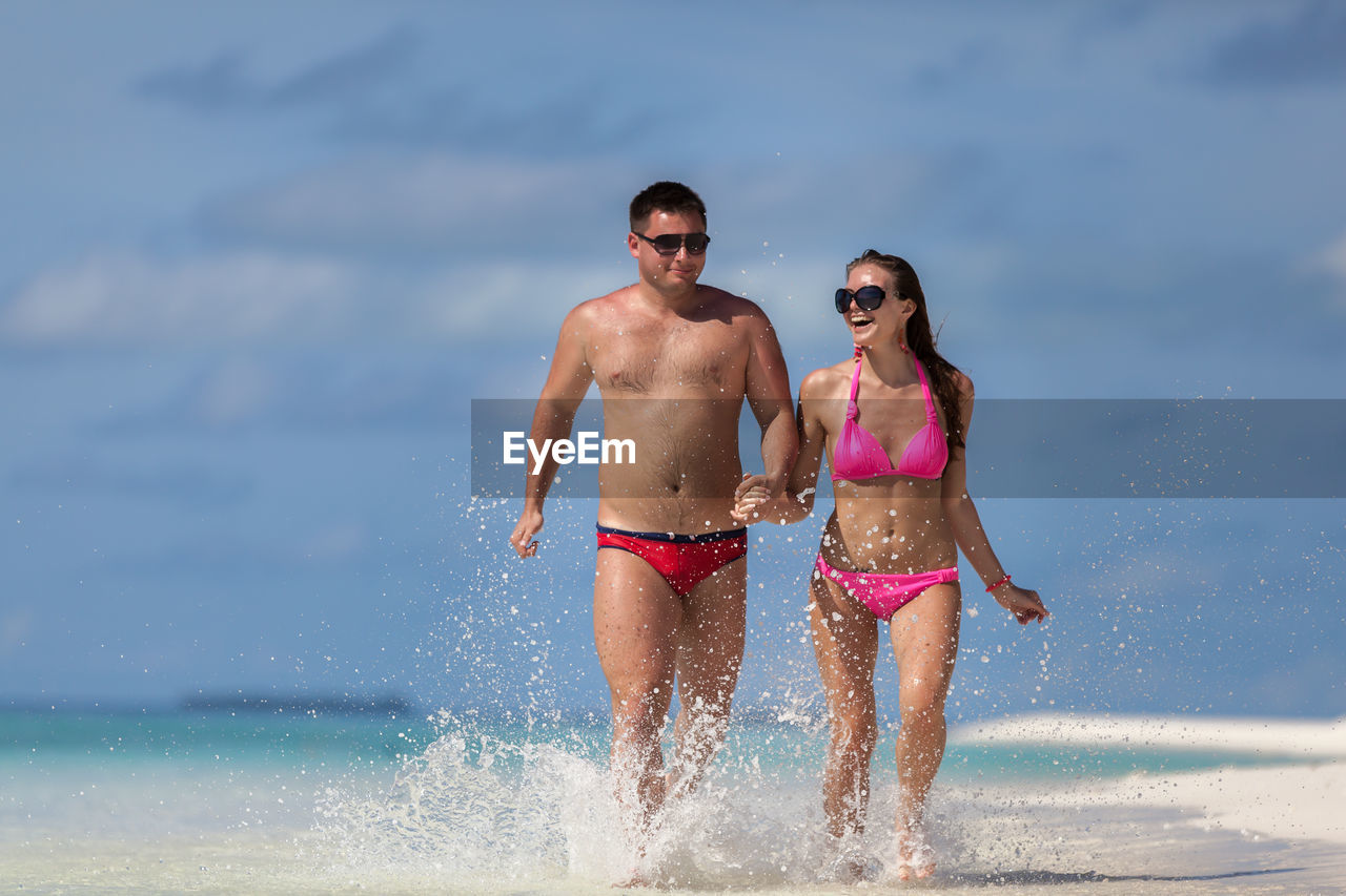 FULL LENGTH OF SHIRTLESS MAN AT SEA