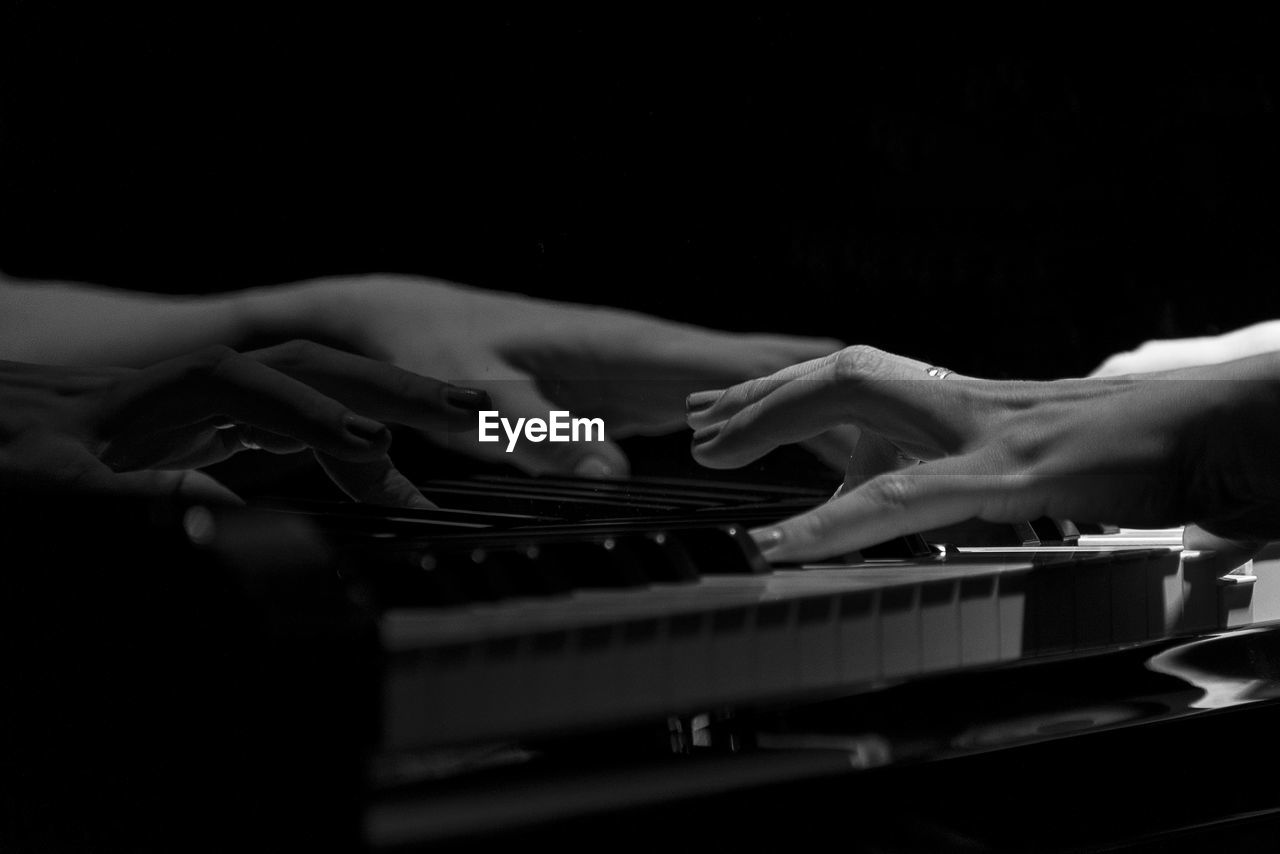 MIDSECTION OF PERSON PLAYING PIANO AT NIGHT