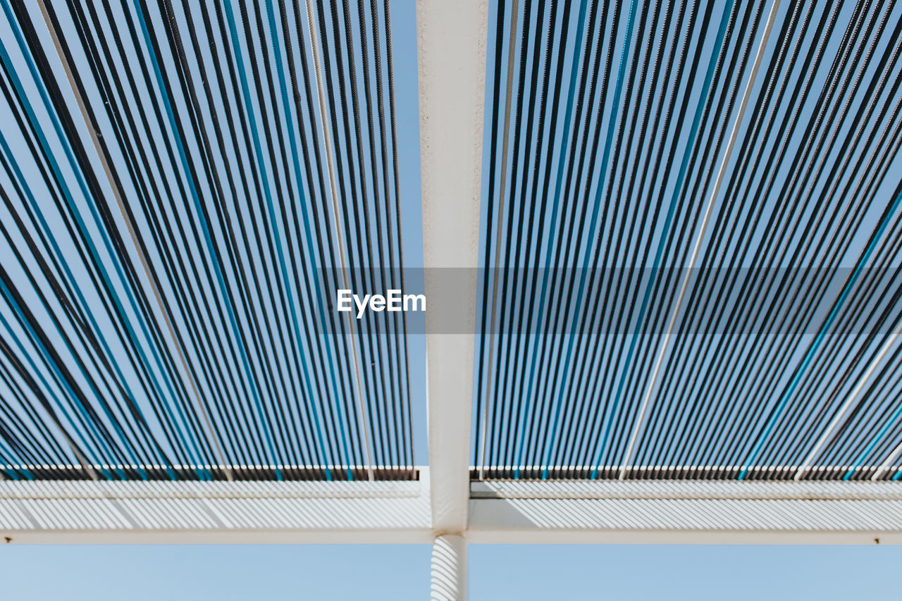 Low angle view of shade structure against clear blue sky