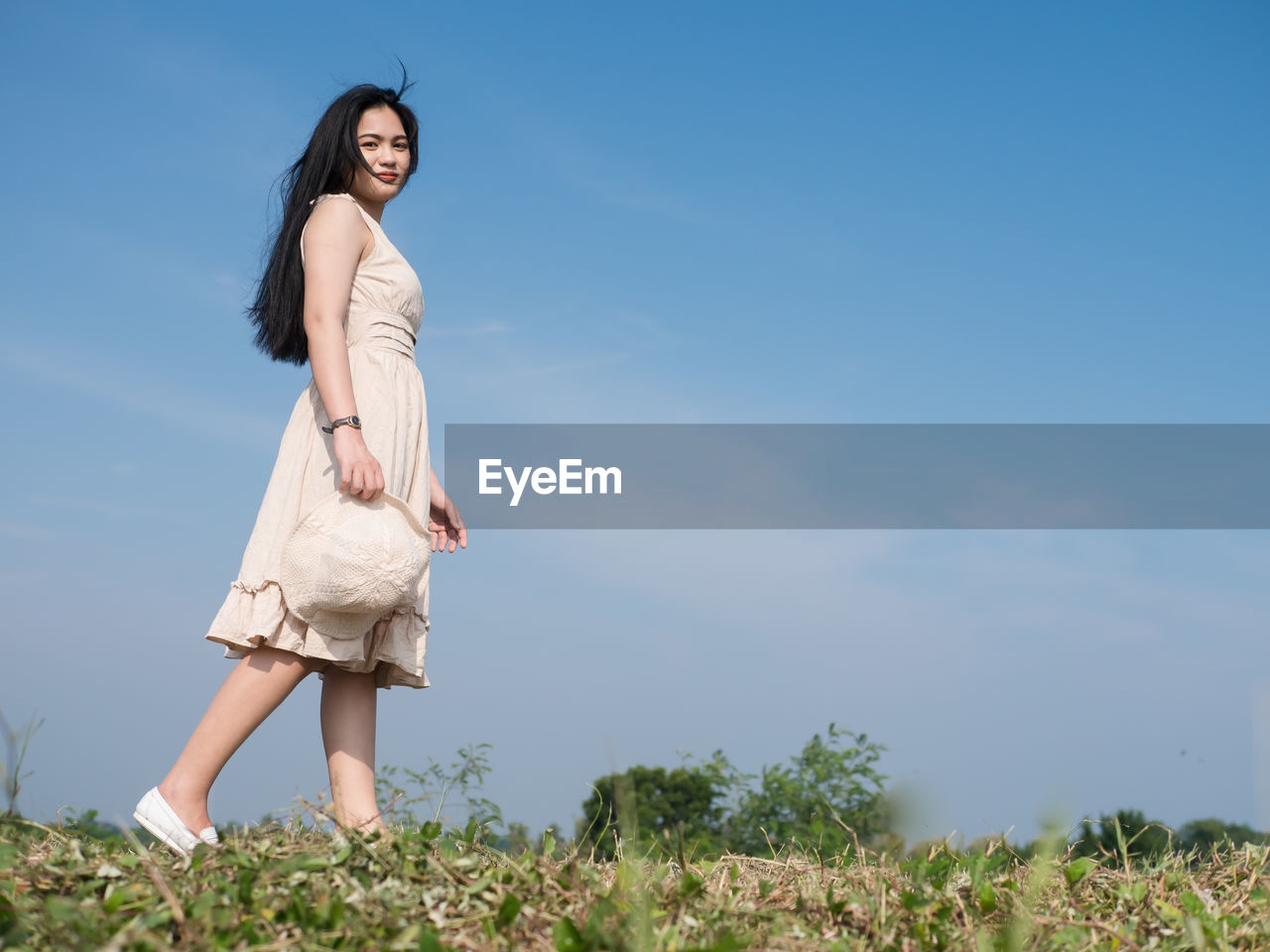 Portrait of young woman against sky