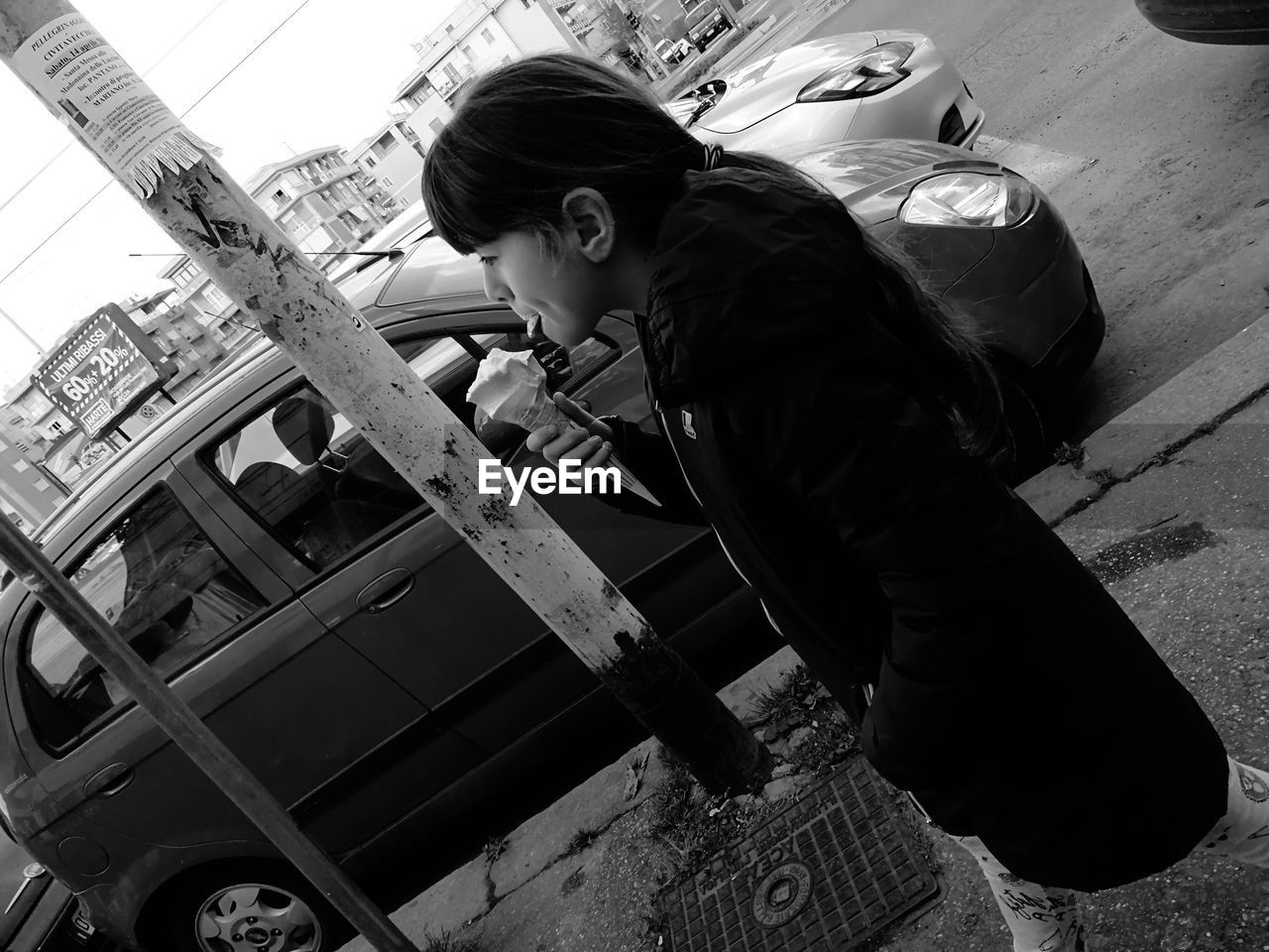 HIGH ANGLE VIEW OF WOMAN LOOKING DOWN WHILE STANDING OUTDOORS