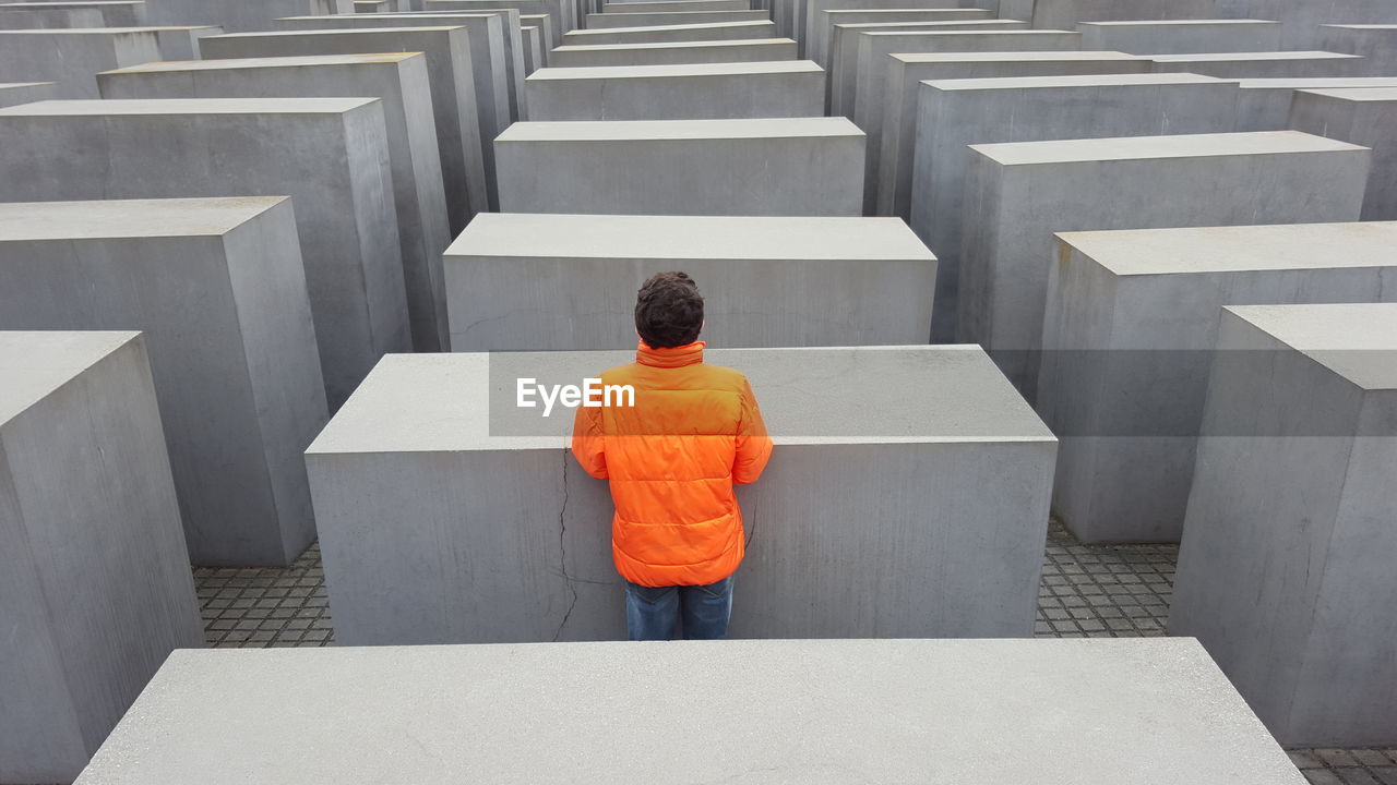 Rear view of man standing by concrete blocks